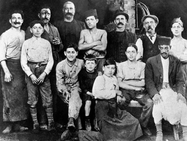 В работилницата на чичото на Камю (Етиен, бъчвар) в Алжир през 1920 г.: Албер Камю (7-годишен) е в c с черен костюм