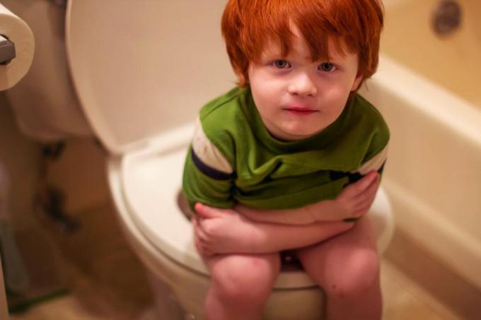 Момченце седи на тоалетна