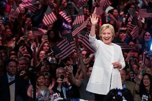 Хилари Клинтън вълни пред тълпа от хора, развяващи американски знамена