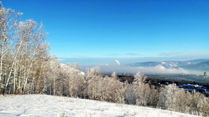Живописен изглед на покрит със сняг пейзаж срещу синьо небе