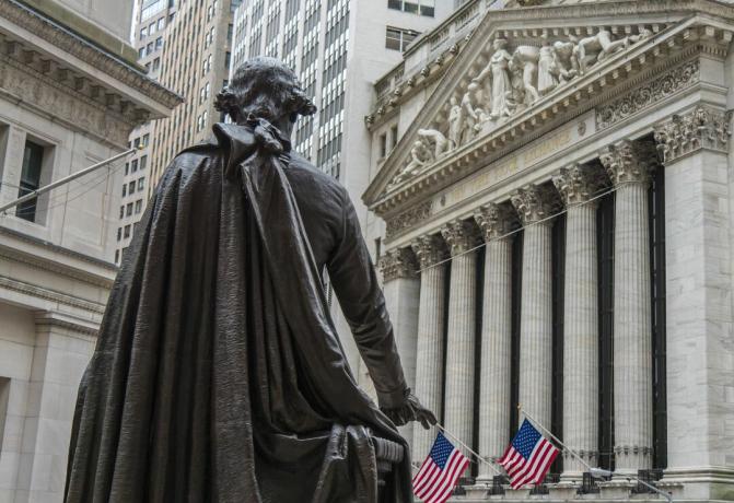 Статуя на Джордж Вашингтон гледа към сградата на фондовата борса в Ню Йорк на Широката улица от Националния мемориал на Федералната зала на Уолстрийт в Ню Йорк.