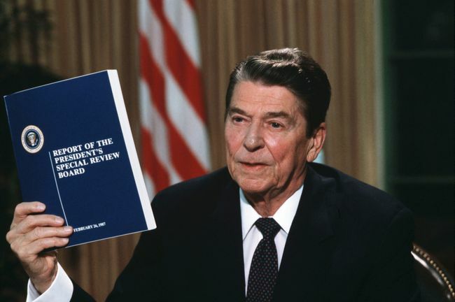 Президентът Роналд Рейгън държи копие от доклада на комисията на Кулата относно скандала Иран-Контра