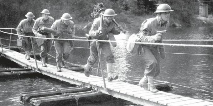 Американски войници преминават през малък понтонен мост.