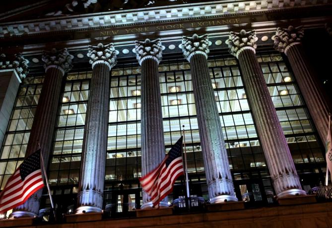 Нощен изглед, гледащ през стъклената фасада на стената на Нюйоркската фондова борса (NYSE), проектиран от Джордж Б. пост