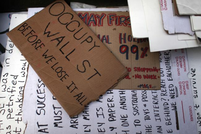 Купчина протестни знаци „Окупирай Уолстрийт“.