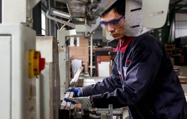 Служител, работещ върху алуминиеви изделия във фабрика в Zouping в източната китайска провинция Шандонг