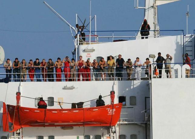 Сомалийски пирати, държащи търговския кораб MV Faina, стоят на палубата на кораба с членове на екипажа на 19 октомври 2008 г.