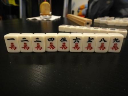 Костюмът на характера на набор от маджонг плочки, седнал на маса.