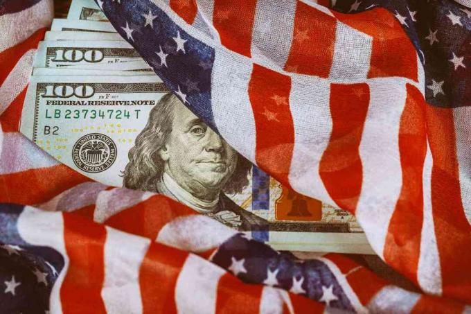 Флаг на САЩ, увит около стодоларови банкноти.