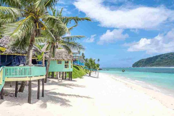 Поглед по плажа Lalomanu, остров Upolu, Самоа, от пъстри хижи от самоански плаж, които са алтернатива на хотел или курортно настаняване