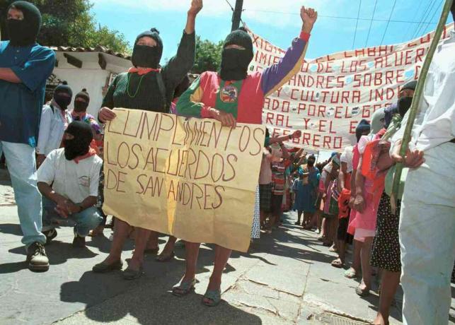 Две жени държат знак, призоваващ правителството да спазва споразуменията от Сан Андрес