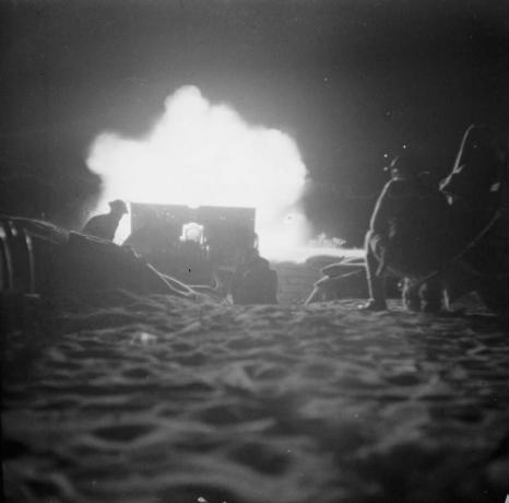 Снимка на артилерийска част, стреляща през нощта.